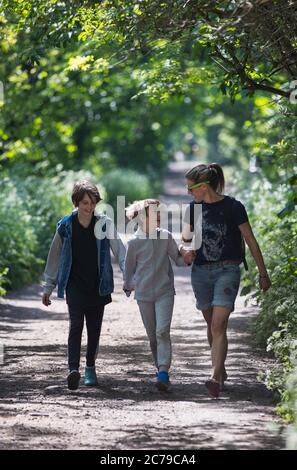 Mother and sons walking on sunny park path Stock Photo