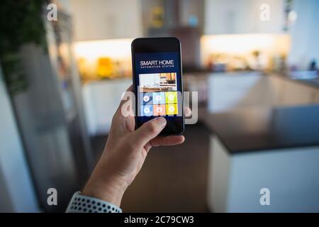 POV Man using home automation on smart phone screen Stock Photo