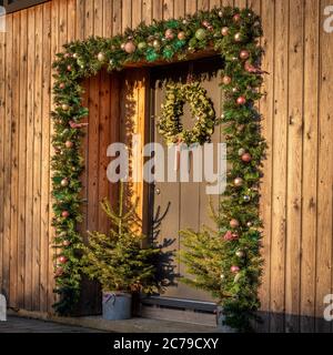 Festive decoration around door on modern timber clad house. Stock Photo
