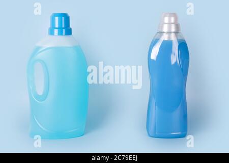 Bottles of detergent and fabric softener on blue background. Containers of cleaning products, household chemicals. Liquid laundry detergent and Stock Photo