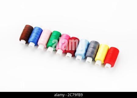 Colorful cotton craft sewing threads multicolored in a row isolated on a white background. Stock Photo
