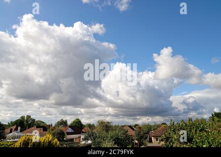 Dramatic cumulus cloud formation forming over rooftops Stock Photo