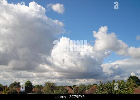 Dramatic cumulus cloud formation forming over rooftops Stock Photo