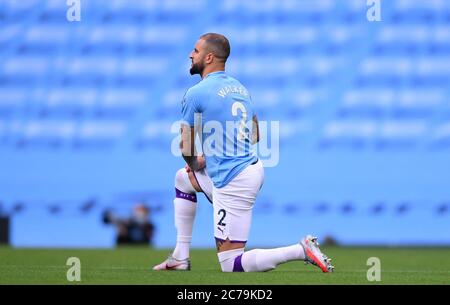 Manchester City's Kyle Walker takes a knee in support of the black lives matter movement before the Premier League match at the Etihad Stadium, Manchester. Stock Photo