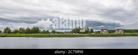 Dramatic clouds near a river in the dutch countryside Stock Photo