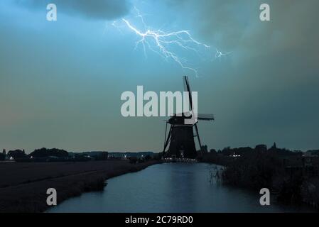 Dutch windmill in stormy weather with lightning bolt Stock Photo