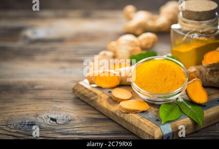Turmeric powder and turmeric roots on the wooden table Stock Photo