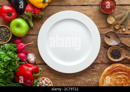 Top view of frame various products, herbs, oriental spices, white plate with space for text on aged wooden background, horizontal, layout, copy space Stock Photo