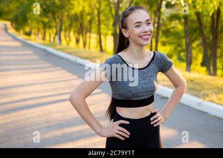 Closeup portrait of sporty athletic woman in sportswear smiling in camera. Stock Photo