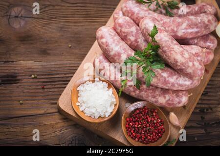 Raw sausages on the wooden board Stock Photo