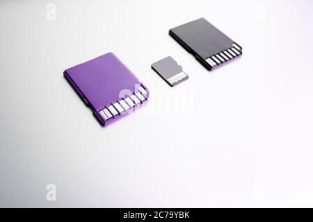 purple and black SD memory cards on white surface, selective focus. black SD memory card on wood texture concept Stock Photo