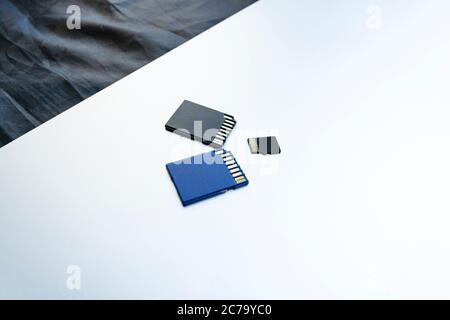Close-up three memory cards lie on a silver tablet surface. Media concept. Memory for gadgets and devices, copy space for text Stock Photo