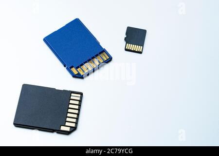 Three micro SD memory cards on white background. Memory cards for digital files. Flash drives lie on a gray surface Stock Photo