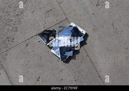 Broken screen mobile phone lies on ground Stock Photo