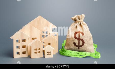 Residential houses and a dollar money bag. Property real estate valuation. Buying and selling, fair price. Calculation of expenses, construction and r Stock Photo