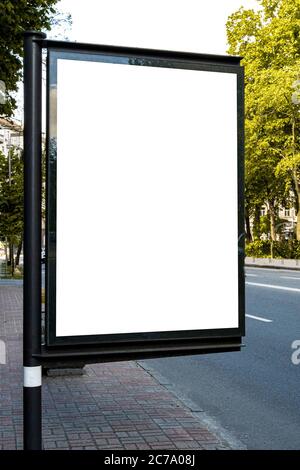Lightposter citylight mockup. A small billboard in the city near the roadway white white space for advertising, vertical image Stock Photo