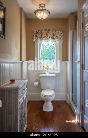 Toilet in small narrow bathroom with stained glass window, Philadelphia, USA Stock Photo