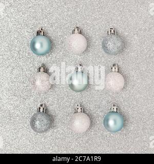 Square pattern made of Christmas balls on a silver textured background. Glowing festive composition. Stock Photo
