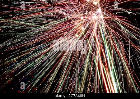 Colourful fireworks exploding in night sky long exposure light trail Stock Photo