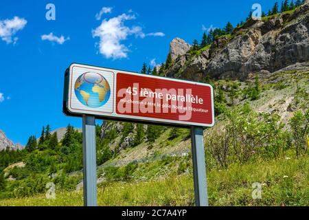 Red sign with globe indicating the 45th parallel in the French Alps, near Briançon Stock Photo