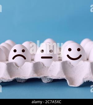 Customer service evaluation and satisfaction survey concepts. Unhappy normal and happy faces on the eggs with blue background. Stock Photo