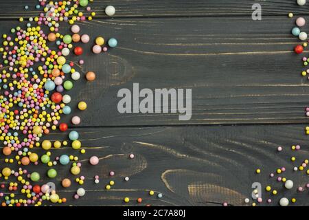 Colorful foam ball texture. Colorful polystyrene foam on a black wooden background Stock Photo