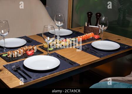 Sushi on the table in the restaurant. Served table with plates and glasses. It's a beautiful serve. Stock Photo