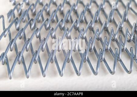 Mesh tape made of wire. Wire weave used in industry. Light background. Stock Photo