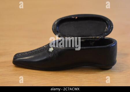 Black shoe shaped snuffbox produced in pocket size or larger for table use to keep snuff dry It holds few days tobacco supply for personal consumption Stock Photo