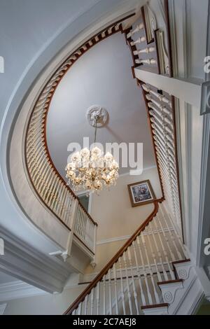 Looking up elegant curved staircase in residential home Stock Photo