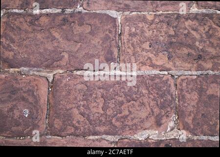 Cobbled ground with reddish colored stone blocks of rodeno forms a textured background Stock Photo