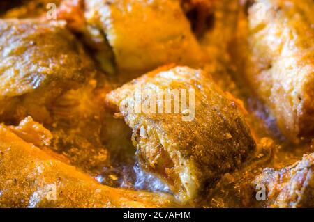 Pieces of navaga fish in batter, fried in oil in a pan. Stock Photo