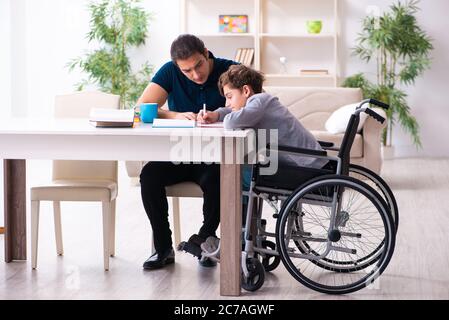 Father and disabled son in the education concept Stock Photo