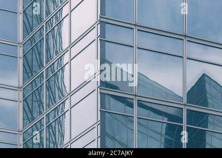 modern office glass building texture in light blue tones for business background, business center generic facade, corner view Stock Photo