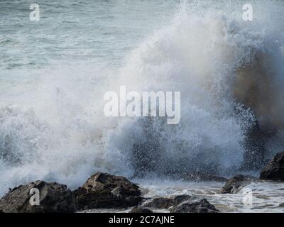 Stormy water, rough seas, closeup ocean waves crashing up against rocks in the harbour during wild weather, Australia Stock Photo