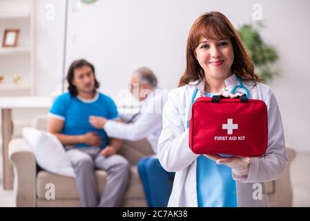 Two doctors visiting sick man at home Stock Photo