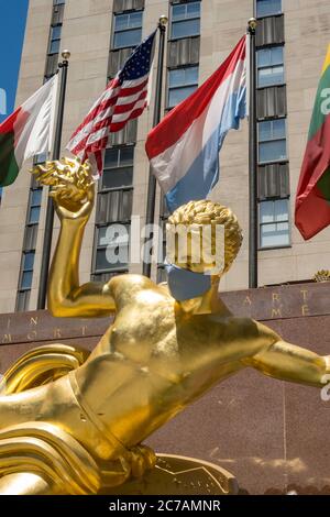 Prometheus in Rockefeller Center features a giant face mask because of the Coronavirus Pandemic, USA Stock Photo