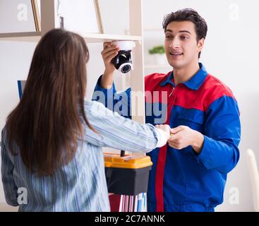 The client getting securty camera installed at home by contractor Stock Photo