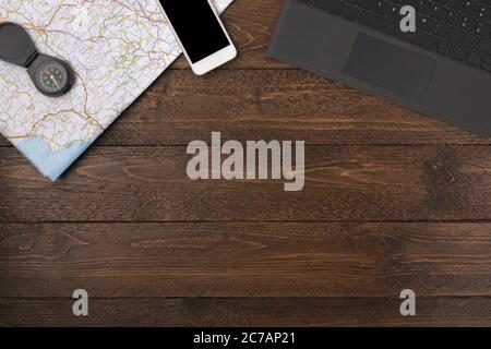 Map, smarthone, compass isolated, on wooden background. Flat lay, top view, copy space. Stock Photo