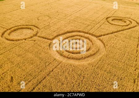 Fake UFO circles on grain crop yellow field, aerial view from drone. Round geometry shape symbols as alien signs, mystery concept. Stock Photo