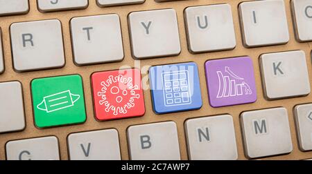 Post covid economic icons shown on keyboard keys closeup Stock Photo
