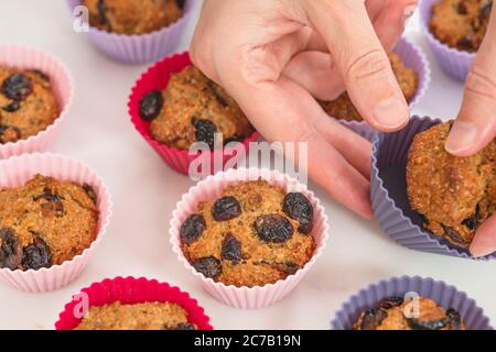 Bran muffins with dry cranberries close up in baking silicon cups on white background. Healthy food, good source of dietary fiber Stock Photo
