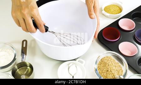 Bran muffins with dry cranberries recipe. Bran, flour, buttermilk, dry berries, and some other ingredients close up on a kitchen table Stock Photo