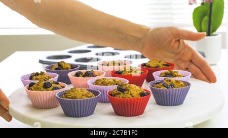 Bran muffins with dry cranberries close up in baking silicon cups  on white background. Healthy food, good source of dietary fiber Stock Photo