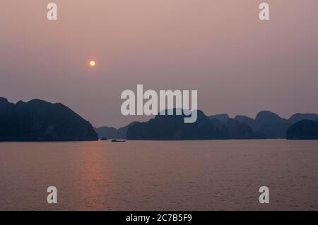 Sunrise over the limestone rock islands of Halong Bay (UNESCO World Heritage Site) near Haiphong in North Vietnam. Stock Photo