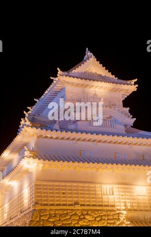 A Japanese castle ice sculpture illuminated at night at the Sapporo Snow Festival in Sapporo, Hokkaido Island, Japan. Stock Photo