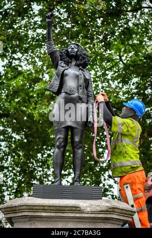 Contractors use ropes to secure A Surge of Power (Jen Reid) 2020, by prominent British sculptor Marc Quinn, which has been installed in Bristol on the site of the fallen statue of the slave trader Edward Colston, as they prepare to remove and load it into into a recycling and skip hire lorry. Stock Photo