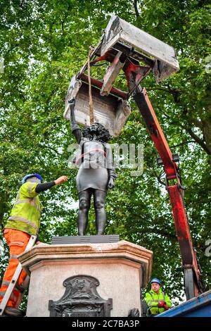 Contractors use ropes to secure A Surge of Power (Jen Reid) 2020, by prominent British sculptor Marc Quinn, which has been installed in Bristol on the site of the fallen statue of the slave trader Edward Colston, as they prepare to remove and load it into into a reCycling and skip hire lorry. Stock Photo