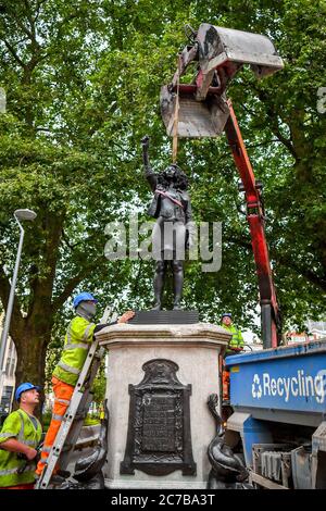 Contractors use ropes to secure A Surge of Power (Jen Reid) 2020, by prominent British sculptor Marc Quinn, which has been installed in Bristol on the site of the fallen statue of the slave trader Edward Colston, as they prepare to remove and load it into into a recycling and skip hire lorry. Stock Photo