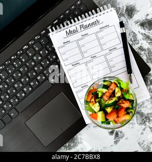 A meal plan for a week. Bowl with vegetable salad in the workplace near the  computer. Lunch in the office during a break between work Stock Photo -  Alamy